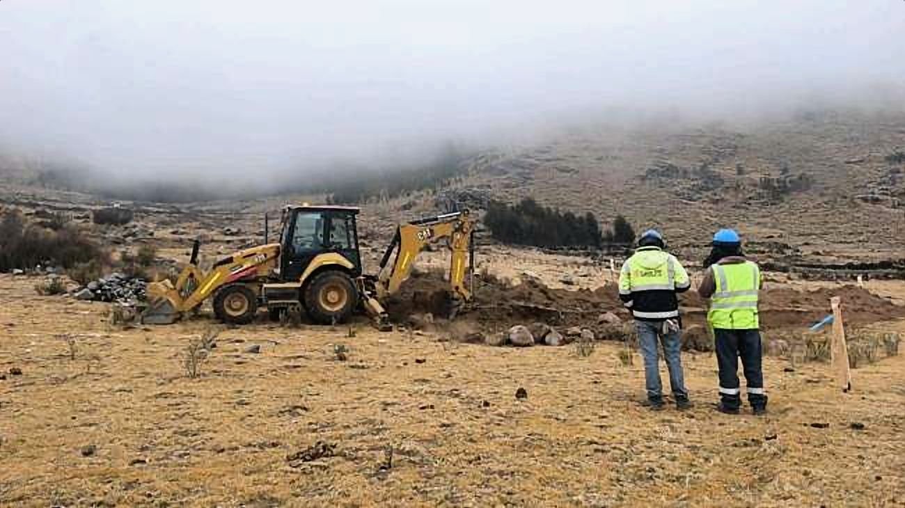 Dos supervisores observan una retroexcavadora en un frente de plataforma