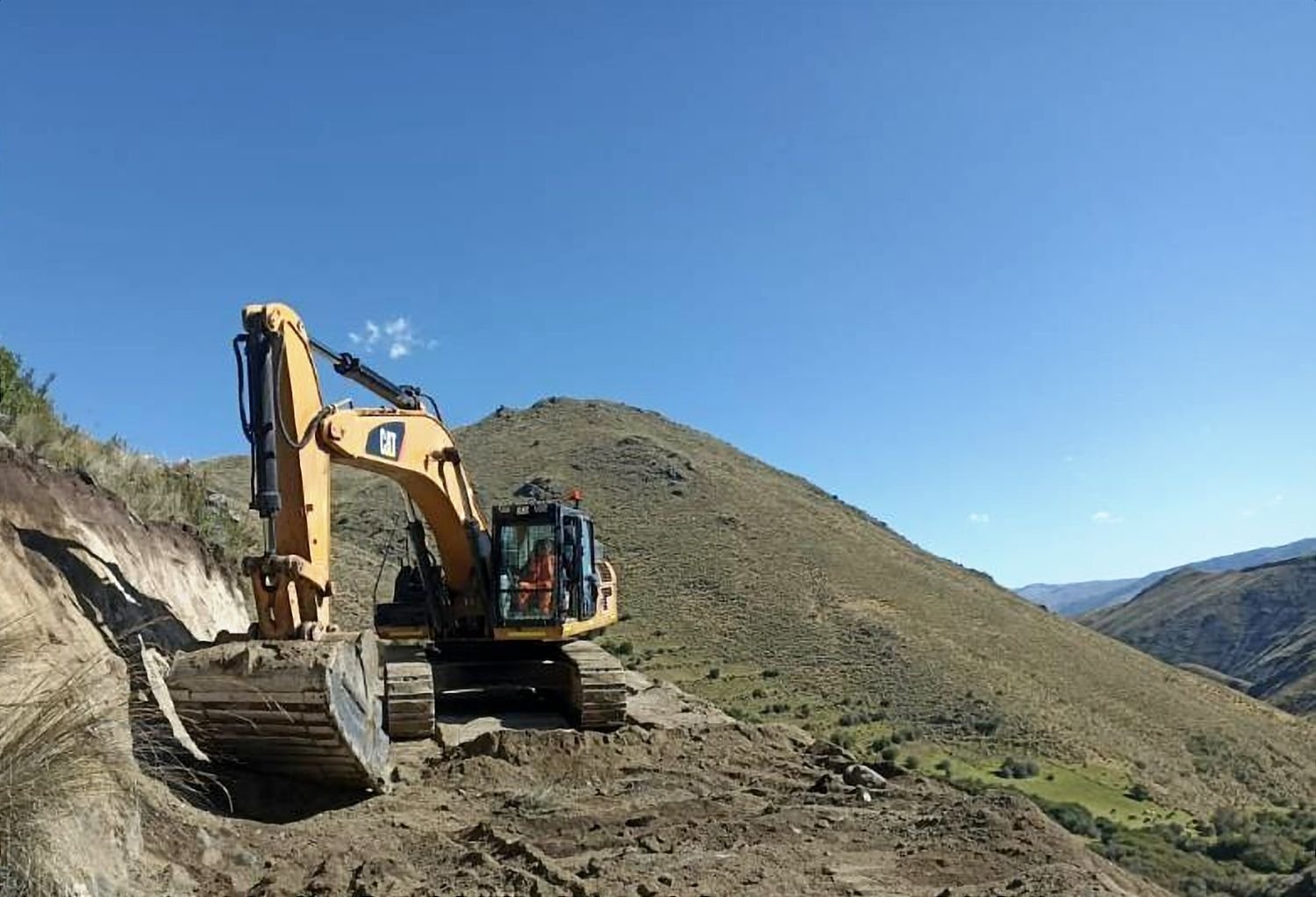 Excavadora cortando una ladera para abrir un acceso