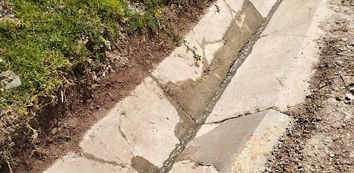Cuneta revestida de concreto recién terminada, con juntas a la vista